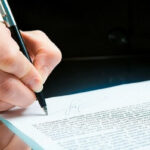 man signing documents