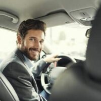 man driving a car looking back