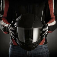 motorcycle rider holding a helmet